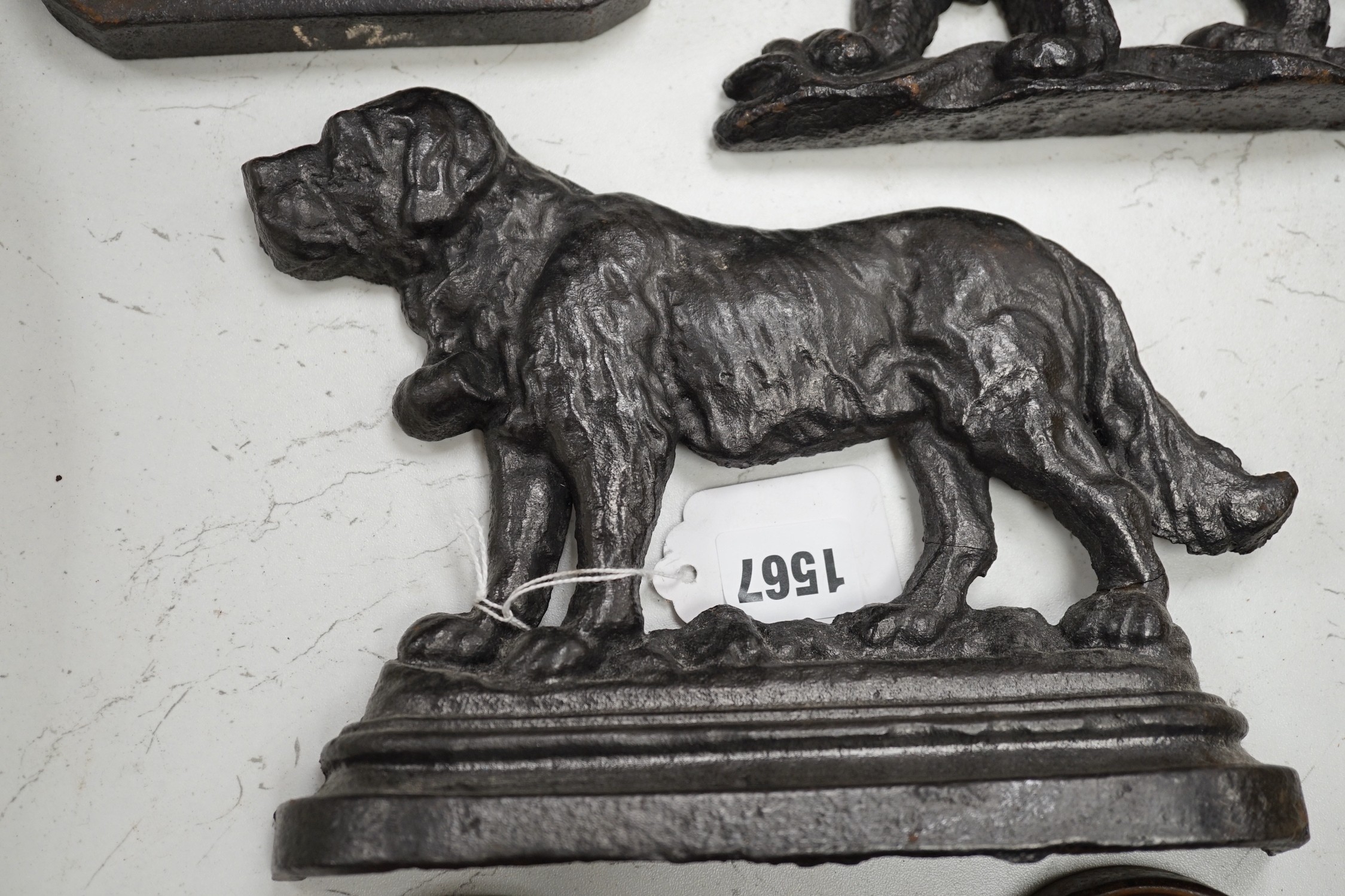 Two lion cast iron door stops, a St Bernard door stop and another, largest St Bernard 18cms high